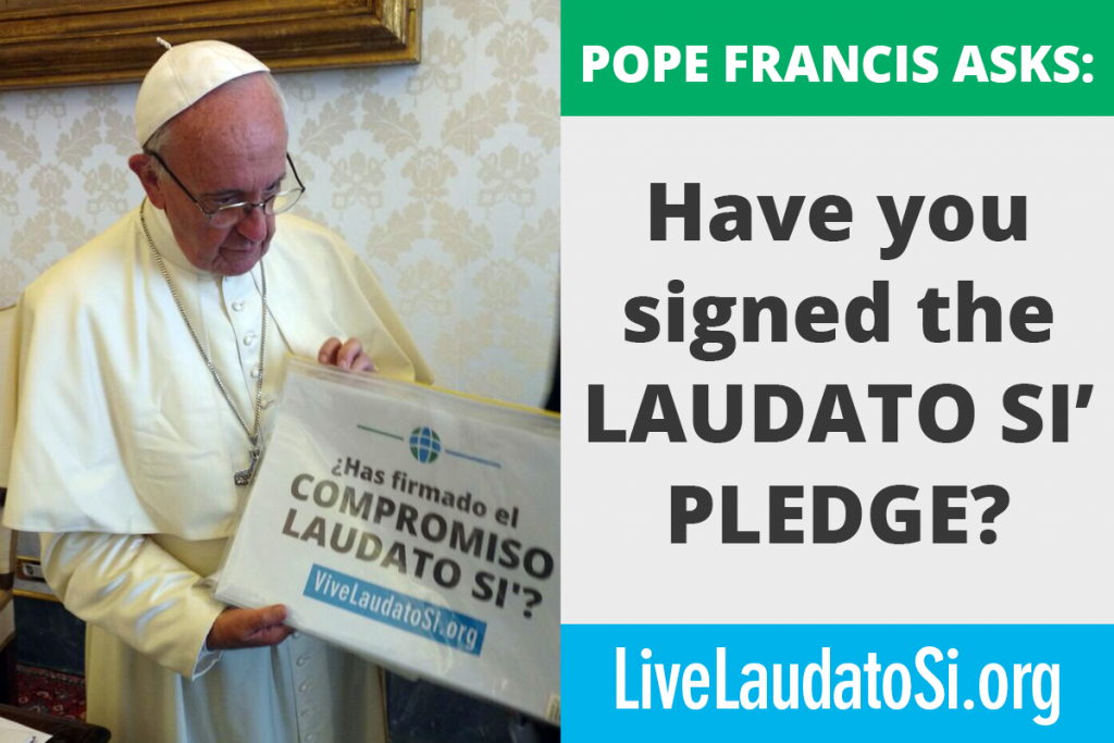 The pope holding the laudato si pledge