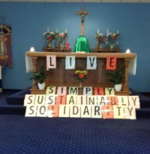 the words simply, sustainably and solidarity in front of a church altar