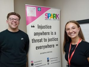 two people in front of a rollup banner