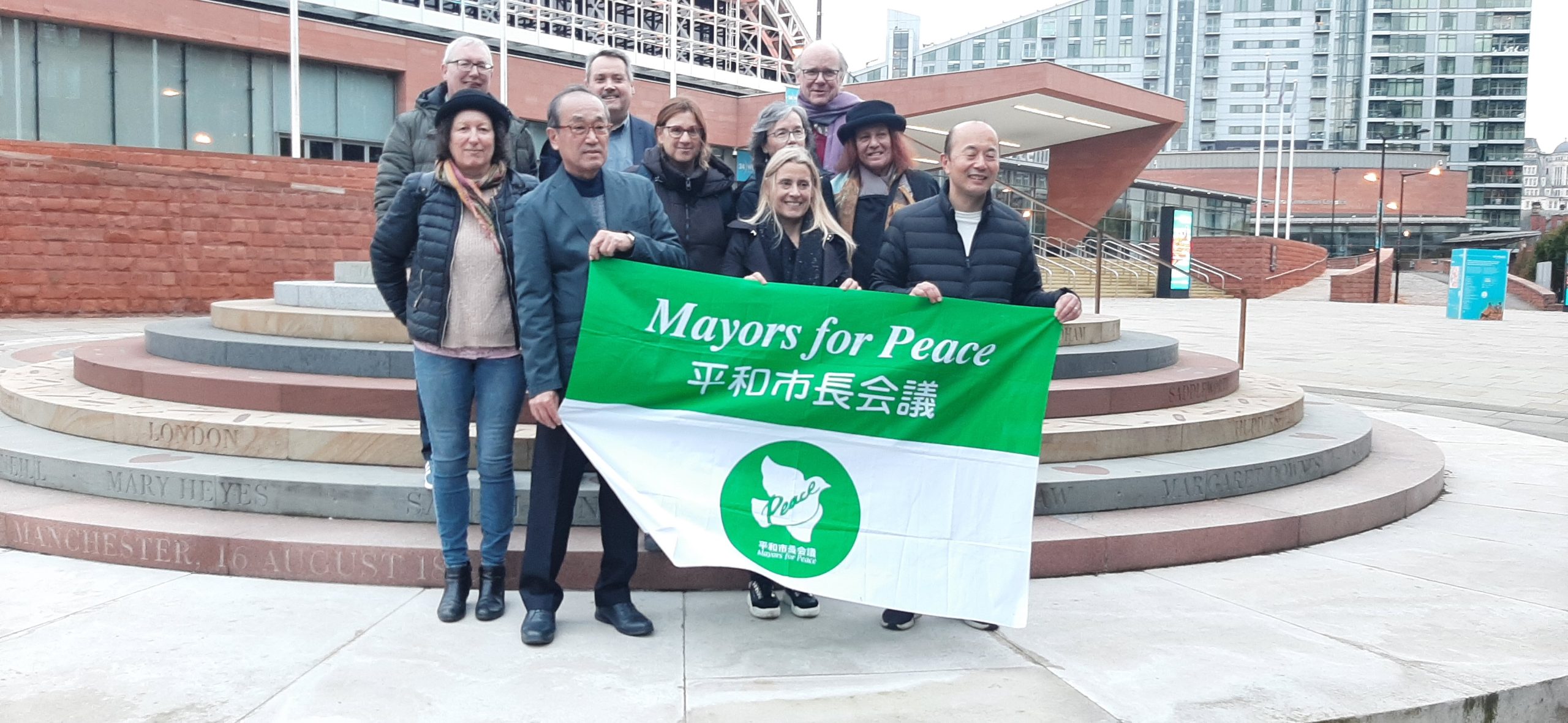 Mayors standing with banner reading 'Mayors for Peace' in English and Chinese